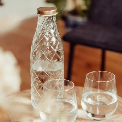 Glasflaske med vand og to drikkeglas